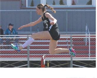 Elizabeth Fedje speeding over a hurdle at the Langdon Invitational. Photo by Larry Stokke.