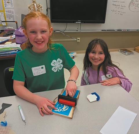 Ava and Olive personalize their signs in the sign etching class. Submitted photo