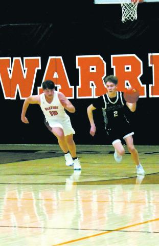 Quinn Passa breaks away from a Warrior defender to drive down the court. Photo by Jamie Rarick.