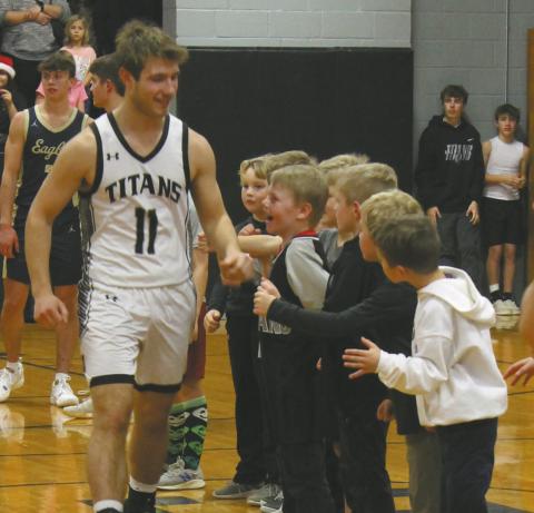 Senior Izak Feltman receives cheers from a line of Tiny Titans prior to the game against North Border. Photo by Jamie Rarick