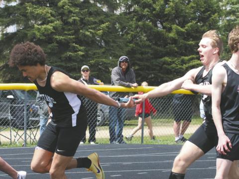 Carter Oberg hands off the baton to teammate Mason Pollestad during the Mens 4X100 Relay. Together with Carter Johnson and Trenten Keena, the relay team finished first with a time of 45.19. Photo by Jamie Rarick