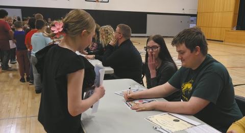 Grant Uggerud signs an autograph for an excited younger student. Photo by Rebecca Davis
