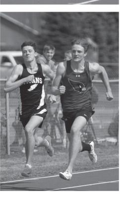 Brady Reilly, left duels with a Carrington runner while competing in the 100 meter dash in Grafton Friday.