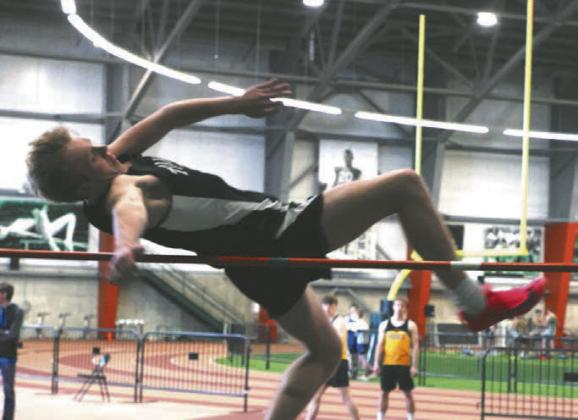 Carter Oberg fights his way over the bar in the boys high jump. Photo by Lyle Van Camp.