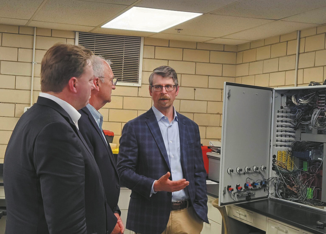 Dan Laudal, executive director and research professor with the University of North Dakota College of Engineering and Mines, provides a tour of the critical minerals research facility in Grand Forks on May 26, 2026, to Sen. Kevin Cramer, center, and Department of Defense official Michael Duffey. (Photo by Jeff Beach/North Dakota Monitor)