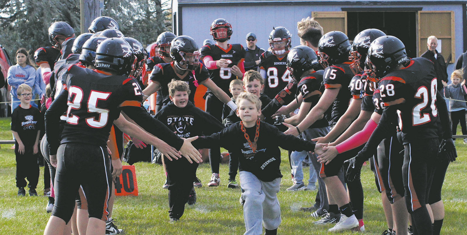 Bomber Buddies Pearce Pokrzywinski and Thomas Manley ran through the lineup with senior Trenten Keena before Saturday's game. Photo by Jamie Rarick