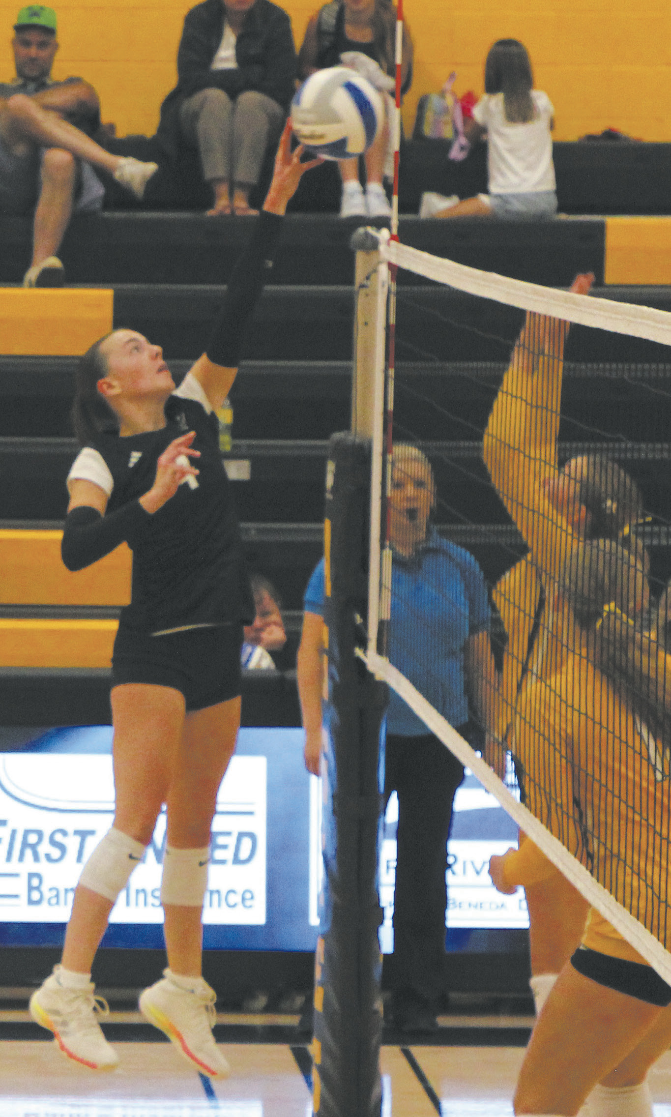 Extending over the net, DVE junior Jocelyn Vold tips the ball against Park River defenders. Photo by Jamie Rarick