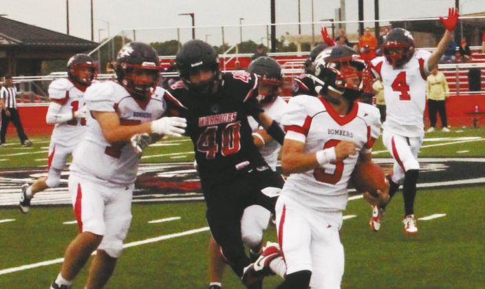 Flanked by his teammates, Trenten Keena carries the ball for another Bomber touchdown. Photo by Jamie Rarick