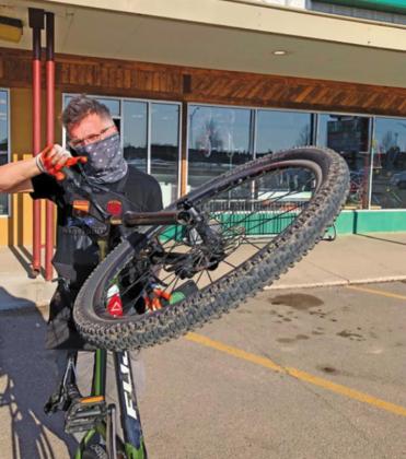 Pat White wears a mask as he wrestles with a bicycle at his Grand Forks business, The Ski and Bike Shop, which has felt the effects of a nationwide bike shortage due at least in part to the COVID-19 pandemic. Photo submitted