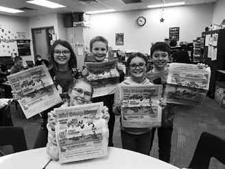 Fourth graders at Kenmore Elementary proudly display a recent copy of Kid Scoop News. From left: Ava Keysor, Connor Petersen, Hannah Alexander, and Beau Hanson. Adley Jensen (sitting front). Photo by Terry Froseth, The Kenmare News.