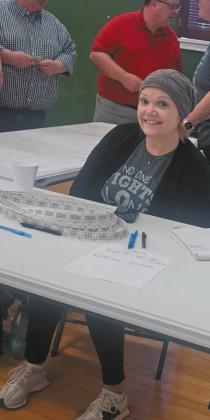 Wearing her “No one fights alone” t-shirt, Kayla Thompson helped sell tickets for the silent auction held during the Pollestad fundraiser last weekend in Drayton. Photo by Christine Jensen