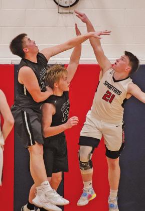 Alex Swanson and Caleb Kartes attempt to block a shot put up by Spartan Blake Jacobsen. VNV Photo by Lesa Van Camp