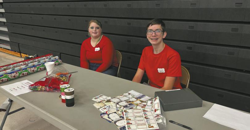 Stephanie Kissee and Jonah Rarick manned a gift wrapping station in the Drayton Gymnasium during the Crafters Market. Photo by Andrea Johnston
