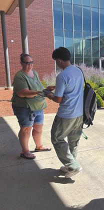 High school students unlock magnetic locking pouches containing their phones after class with a newly established a phonefree policy in 2024. After the success of cellphone bans nationwide, state lawmakers are turning to legislation restricting how much time students can look at screen. (Alixel Cabrera/Utah News Dispatch)