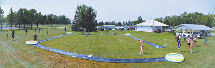Slip ‘N’ Slide had a huge-turn out at Schumacher Park last Friday. An anonymous donor sponsored the entire event, quote, “for the kids.” This is the second year and the plan is to have the event every year. Photo by Duane H.H. Lyon