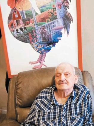 Bobby is photographed here with one of his many completed puzzles that he loves working on. Photo submitted by Arlen Westling.