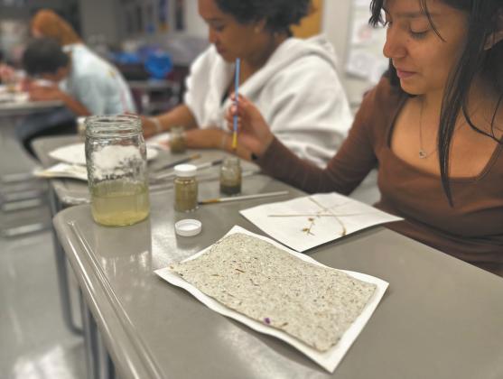 Students Julissa Garcia, and Daphneiris Almonte from the North Valley CTE program paint on prairie paper with pigments made from local soils as part of the Thinking Like a Prairie workshops. Photo Josh Anderson.