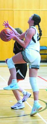 Jaelyn Johnson prepares for a lay up while Midway-Minto attempts to block the shot. Photo by Larry Stokke