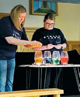 Angie Aasand and Bryanna Halvorson perform a science experiment in front of VBS groups. Photo by Cindy Johnson.