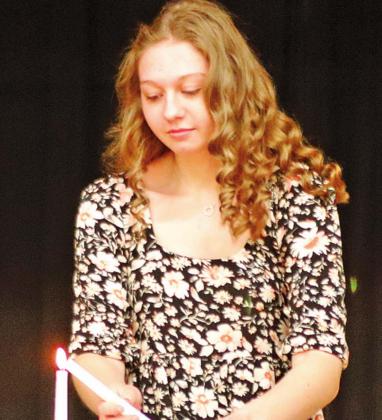 Kayli Staskivige lights a candle during the NHS Induction Ceremony Monday night. VNV Photo by Lesa Van Camp
