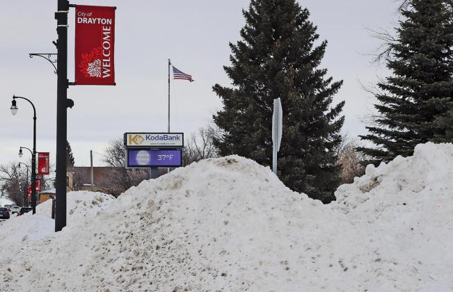 The electronic sign seen in the background beyond the snowpiles created from the street plowing showed a temperature of 37 degrees on Tuesday afternoon. VNV Picture by Lesa Van Camp