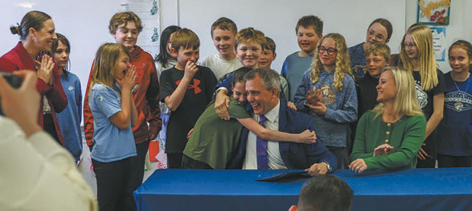 A student at Centennial Elementary gives Gov. Kelly Armstrong a hug after he gave her the pen he used to sign House Bill 1160, which requires North Dakota public schools to adopt phone-free school policies, on Friday, April 25. Submitted photo.