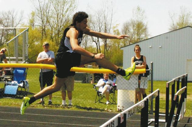 (Left) Soaring over the hurdles, junior Elizabeth Fedje took the lead to a first-place finish in the womens 300m hurdles. (Above) On his approach, sophomore Mason Pollestad extends to clear in the mens 110m hurdles. Pollestad placed 2nd with a personal record of 16.52. Photos by Jamie Rarick
