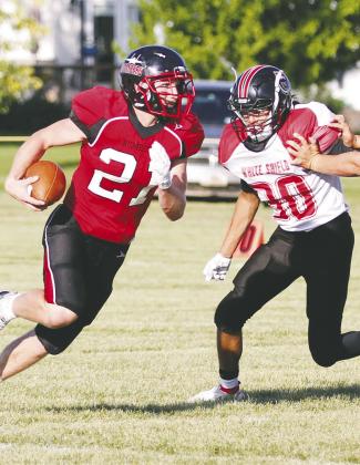 Senior running back Cayden Quibell eludes a tackler in Saturday's game vs. White Shield. Quibell ran for two touchdowns in the Bomber's 43-31 loss to the Warriors. Blocking on the play is Drayton junior Bryce Wimpfheimer (#53). Photos by Mike Alan Steinfeldt.