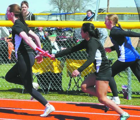 Jocelyn Vold and Mabelline Blanco compete in the 4x100 relay finishing third. Photo by Larry Stokke.