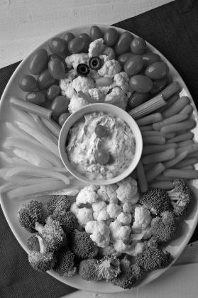Bring a healthful dish to your next holiday party. How about a veggie tray shaped like a snowman with spinach dip? Photo by Pixabay.
