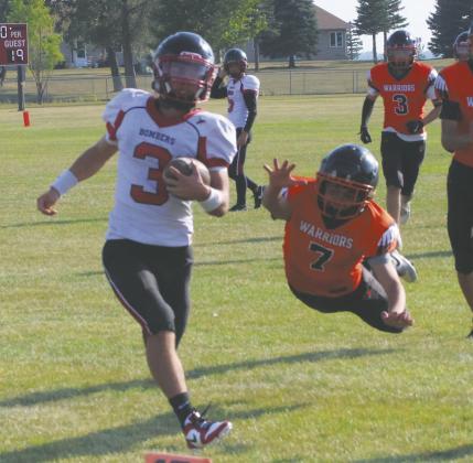 Warrior defender Kingston Fox leaps for the tackle, narrowly missing Trenten Keena as he crosses the goal line for a touchdown. Photo by Jamie Rarick