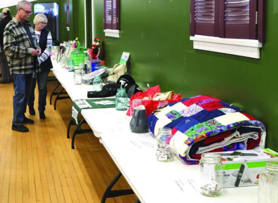 Murph and Patti Thompson decide what to bid on during the silent auction at the benefit held for Don Staskivige.