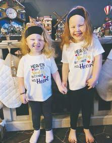 Hadley and Everly hold hands while wearing matching shirts which say, “Heaven has my Daddy but I have his heart.” Photo compliments of Megan Kalka.