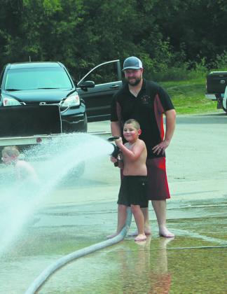 Fire hose fun was a hit on the hot day. Photo by Andrea Johnston