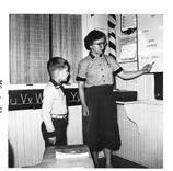Clint is pictured here in the school year of 1955-56 with his first grade teacher, Carol Hoselton, who taught him how to read and write at Morrison District 13 north of Drayton.