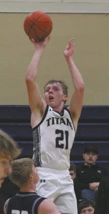 Flying over Sargent County defender Eli Olson, DVE’s Carter Oberg goes for three. Photo by Jamie Rarick