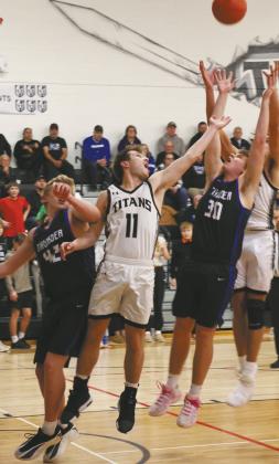 DVE senior Isaac Feltman extends to go for the rebound past Hatton-Northwood players Owen Poppema and Trayson Monkeby. Photo by Jamie Rarick