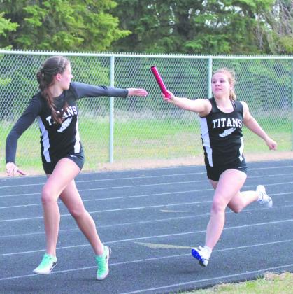 DVE's Violet Hoyles stretches forward for the hand-off to teammate Rosalyn Fedje during the Women's 4X200 Relay. Along with Cynthia Schultz and Peyton Larson, the team earned a 7th-place finish at Saturday's regional competition in Mayville. Photo by Jamie Rarick