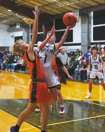 Drew Passa puts up a shot in the paint and finished the game with five threepoint baskets and a total of 18 points. Photo by Larry Stokke