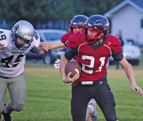 Cayden Quibell runs the ball while Raider Zach Volson is being slowed from getting the tackle Friday night on the Drayton field. VNV photo by Lesa Van Camp
