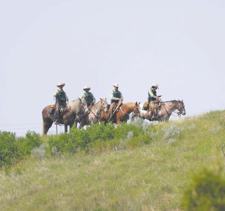 U.S. Forest Service personnel monitor a bluff by horseback during a visit from President Donald Trump on July 1, 2026, in Medora, N.D. Photo by Kyle Martin/For the North Dakota Monitor
