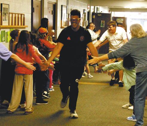Daniel De Souza, gives high five’s for luck while leaving for the state music competition. Photo by Jamie Rarick