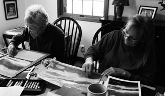 After completing their base layer of oil pastels, Laurel Brusseau (left) and Sylvia Moore (right) brainstorm on how to bring out the finer details in their works. Photo by Mary Ellen Kirking.
