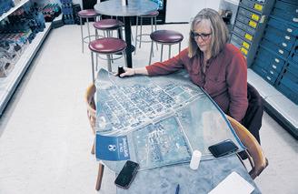 Patti Larson displays a map of the town of Sheyenne at a back table at Route 281 Repair and Convenience on Feb. 13, 2023. Photo by Michael Standaert.