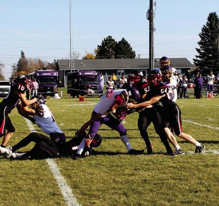 Chey Sehrt, Jerimiah Johnson, and Landon Mapel work together to bring down the Eagle ball carrier. Photo by Jamie Rarick.