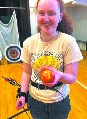 Ruby H. holds up the apple she shot off the target. Submitted photo.