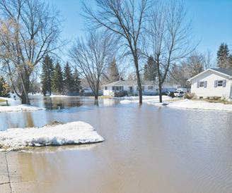 This picture was taken looking south along First Street in Minto on Monday. Water from overland flooding caused the Forest River at Minto to spike to more than 3 feet above flood stage prompting closure of Highway 81. Many residents needed to sandbag their homes in an attempt to keep the water out. Photo by Mike Alan Steinfeldt.
