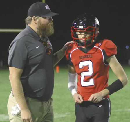 Coach Foster tells quarterback Quinn Passa what play he wants next. Photo by Lyle Van Camp