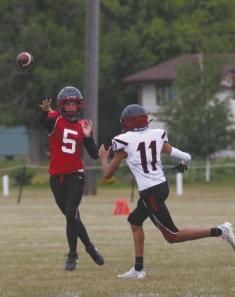 Senior quarterback Max Foss-Pokrzywinski gets the pass off over a White Shield defender. Photo by Jamie Rarick