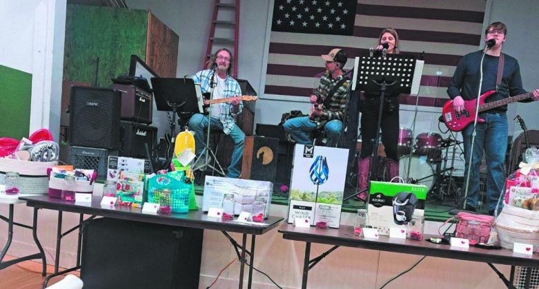 The Homestead Band played on the stage behind a large display of items and baskets that had been donated for the silent auction. Photo by Christine Jensen